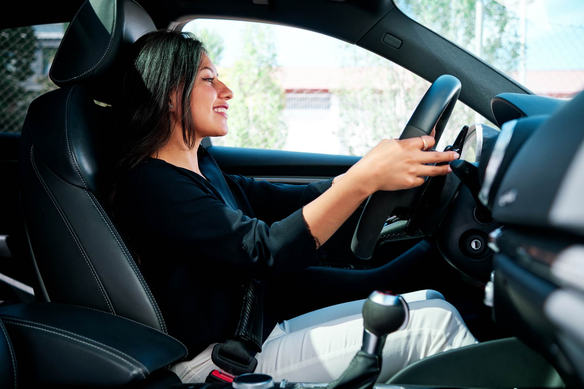 young-latin-woman-driving-luxury-car